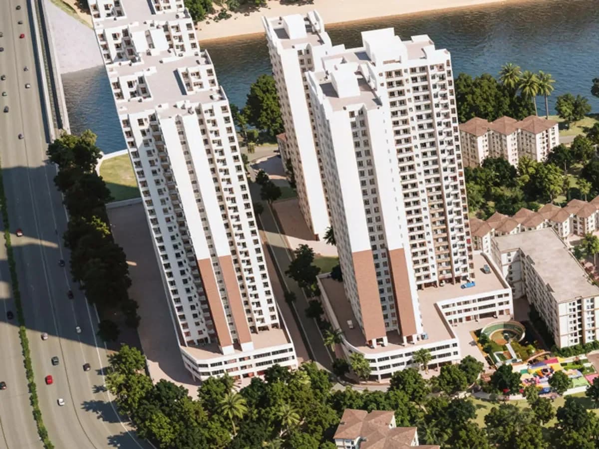 Aerial view of high-rise residential towers beside a waterfront
